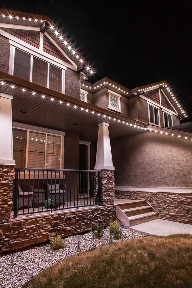 Warm white permanent roofline lighting on a Colorado home at night (photo 70 of 136)