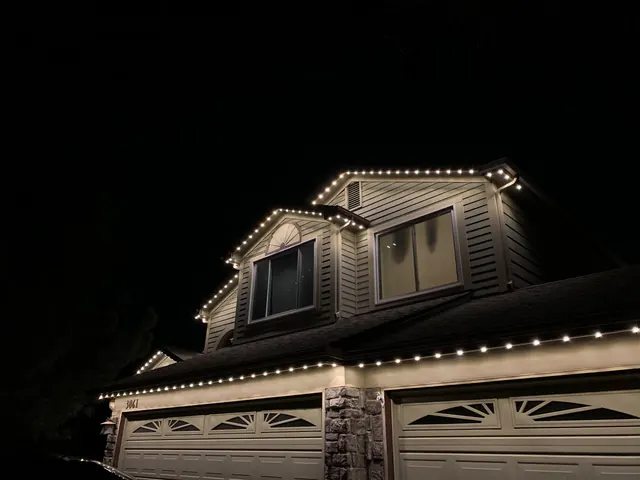 Warm white permanent roofline lighting on a Colorado home at night (photo 127 of 136)